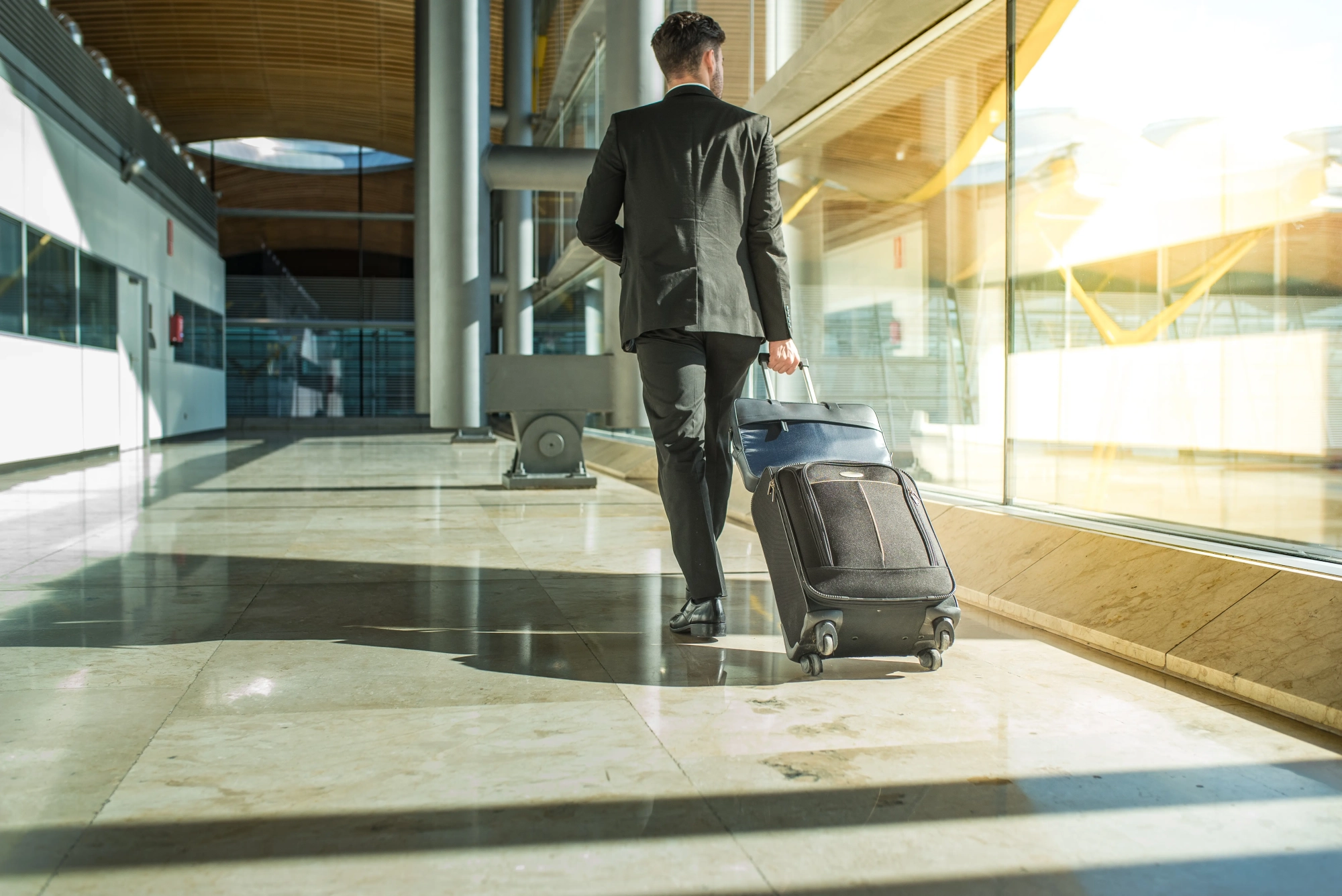 businessman walking with luggage airport Relocation planning
